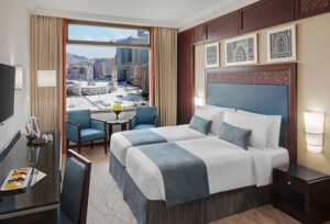 Deluxe room at Anjum Hotel Makkah with comfortable bedding and city view for Umrah pilgrims